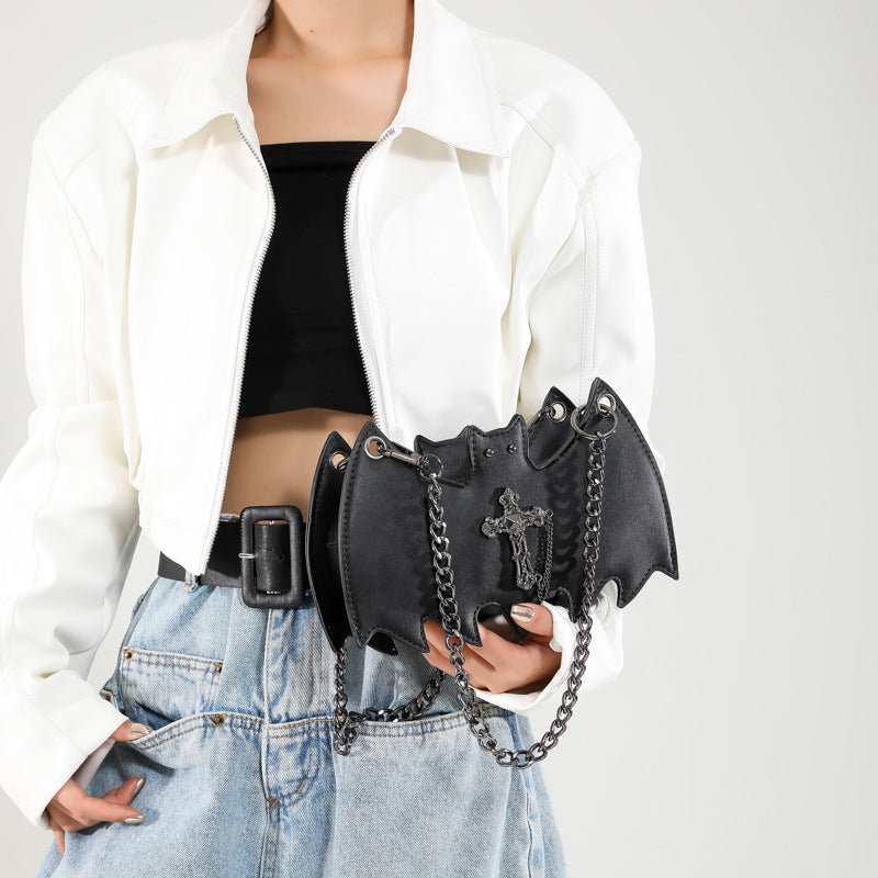 Handbag shaped as a bat being held.