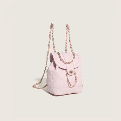 Pink backpack with a chain strap on a light beige background