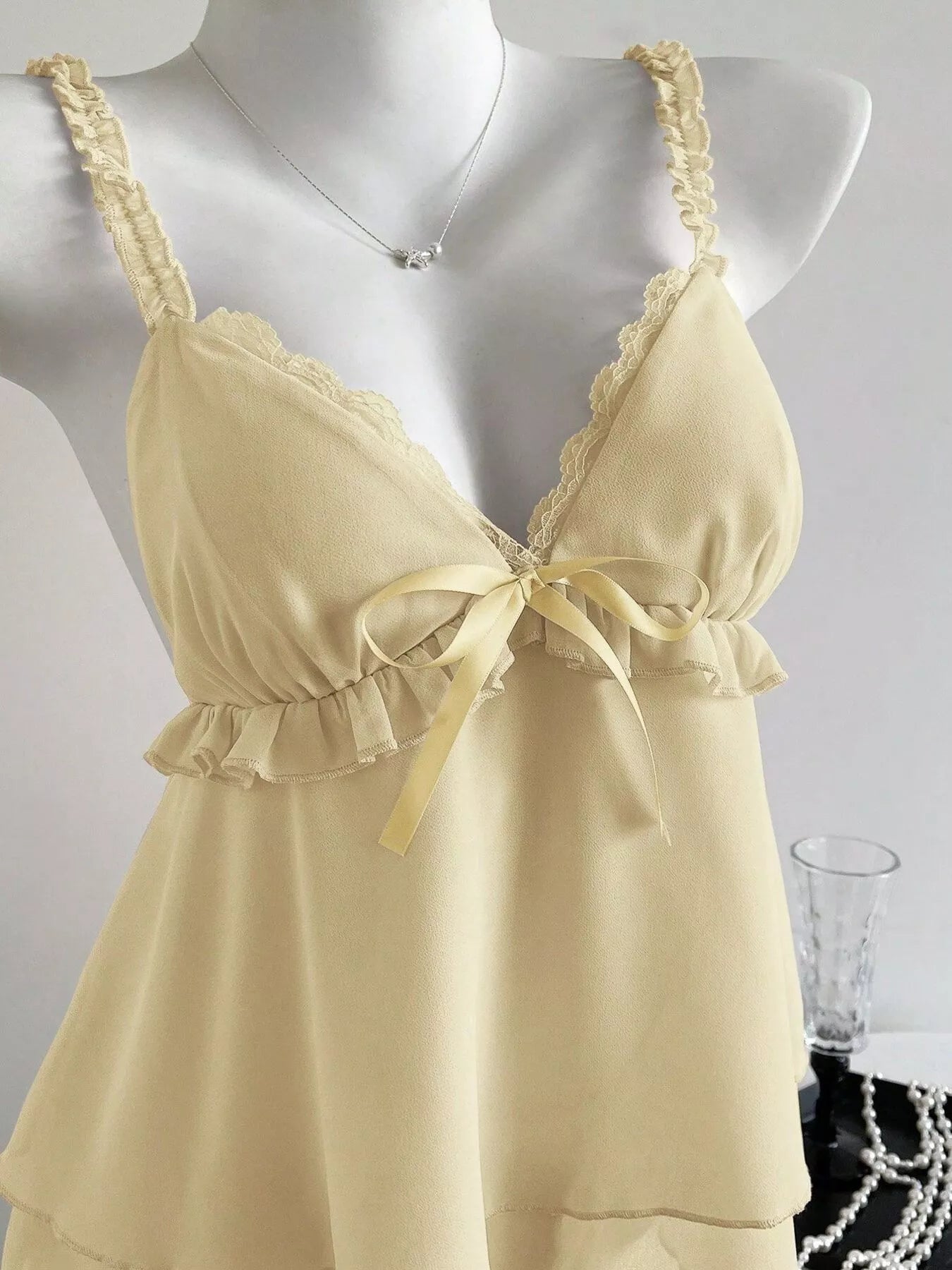 Beige nightgown with lace details on a mannequin against a white background