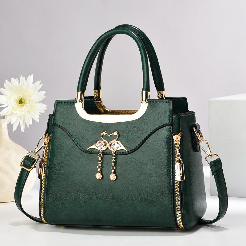 Handbag with gold accents with a single flower and white background.