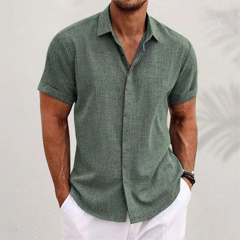 Man wearing a green short-sleeve shirt and white pants against a light gray background