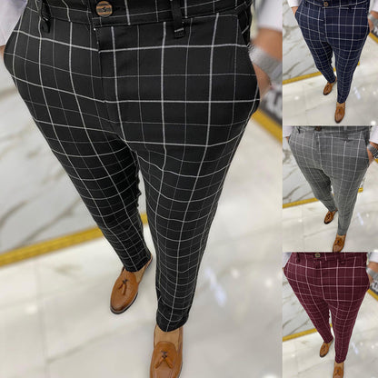 Black checkered pants worn by a person on a light marble floor.