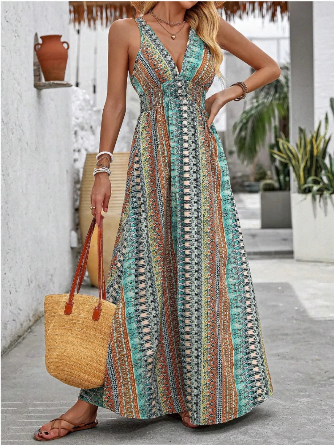 Woman wearing a colorful patterned dress holding a yellow bag outdoors.