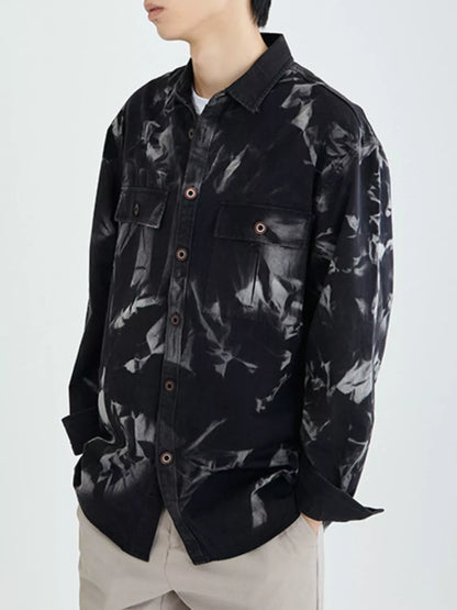 Person wearing a black floral patterned shirt on a white background