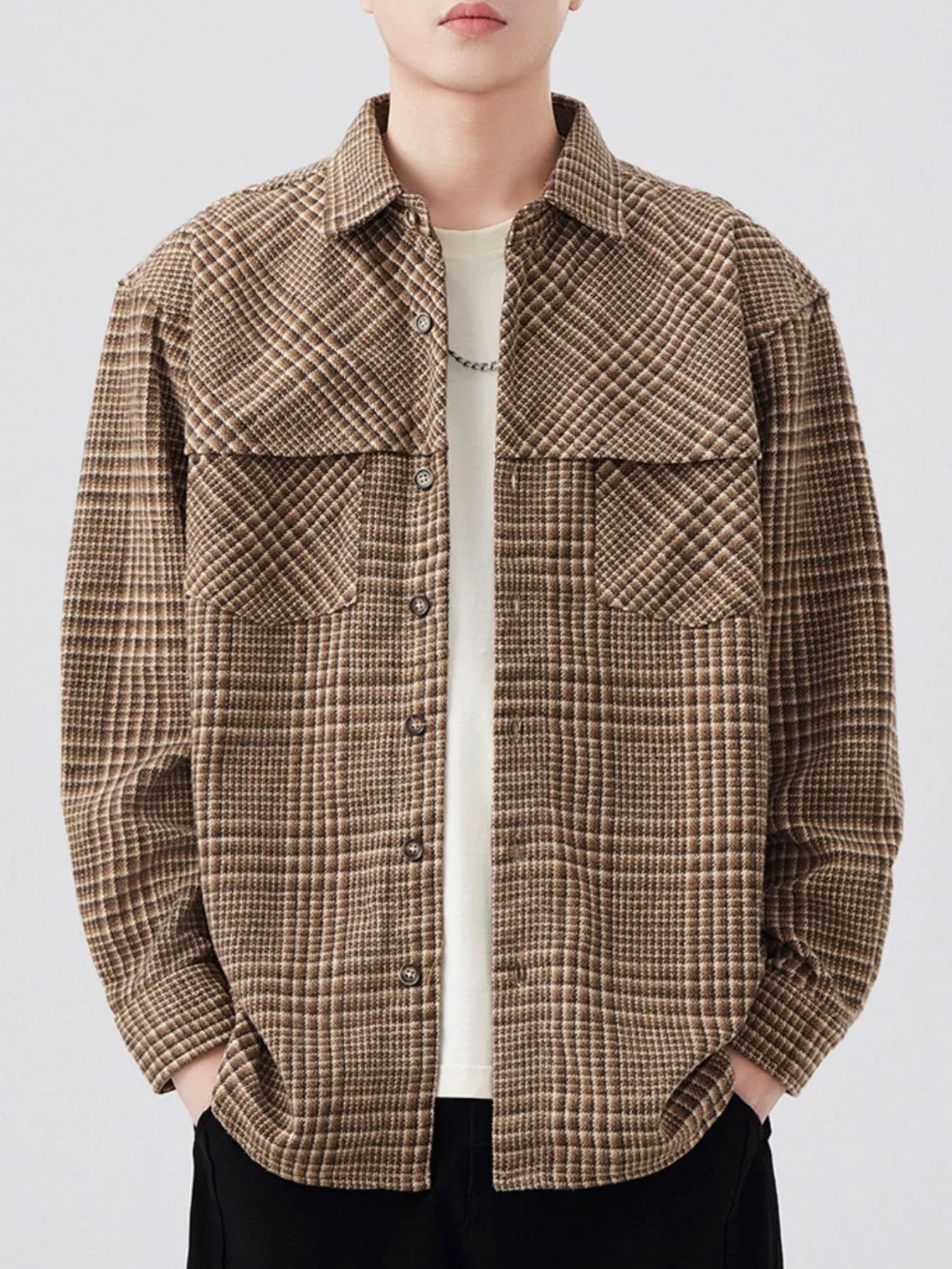Person wearing a brown plaid shirt on a white background
