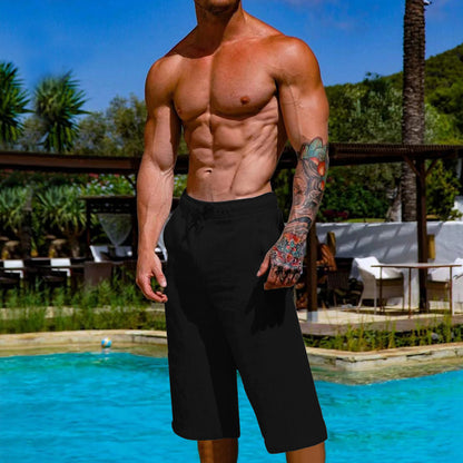 Man with tattoos standing by a pool with a scenic background