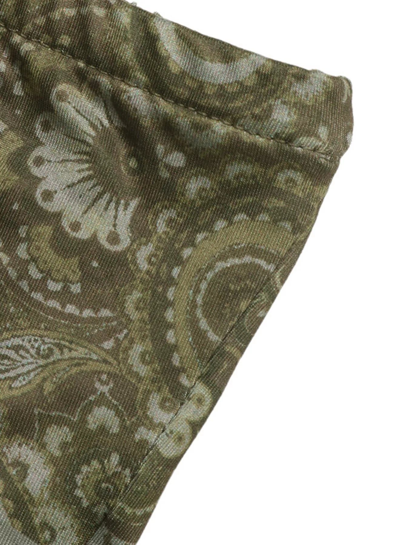 Close-up of a green fabric with a paisley pattern on a white background