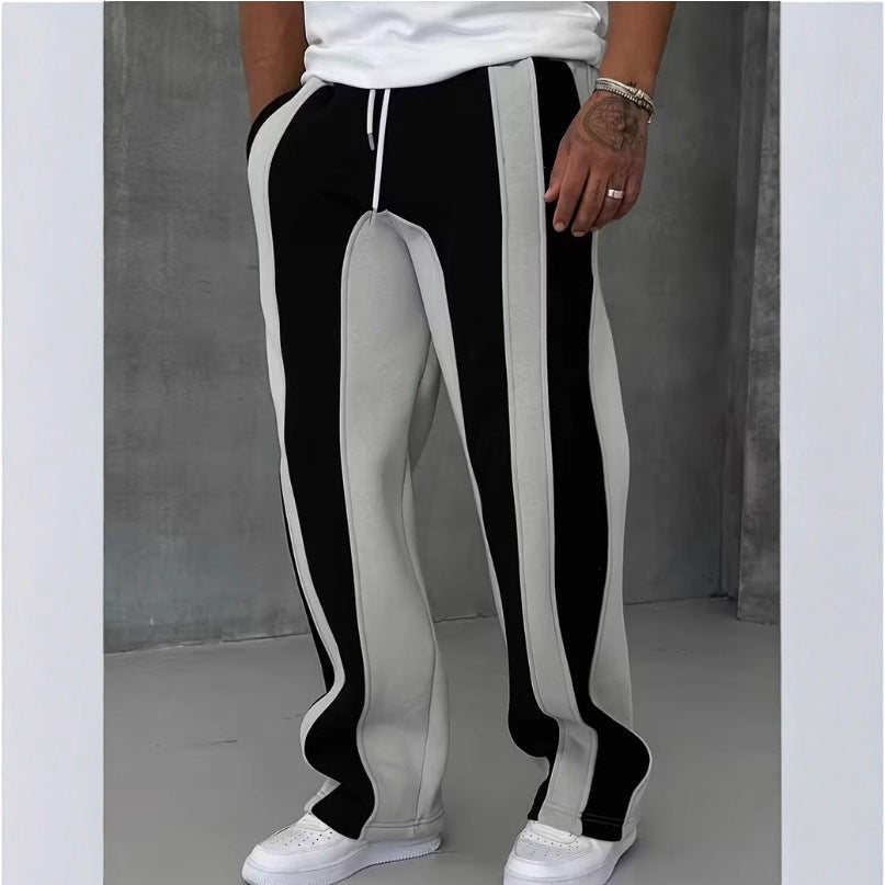 Black and white striped pants worn by a person on a plain background